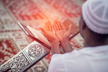 Dindar siyah Müslüman adam camide dua ediyor.