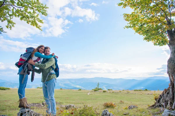 Dva turisté s batohem stojí na vrcholu hory a podívejte — Stock fotografie