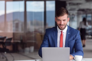 Ofiste dizüstü bilgisayarıyla çalışan gömlekli bir iş adamı. Boşluk ofisi aç