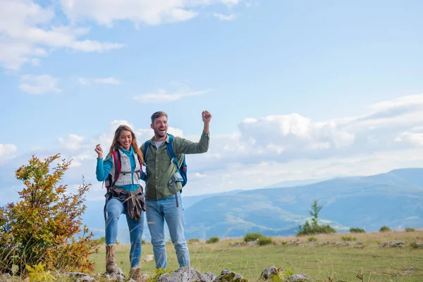Ευτυχισμένοι ταξιδιώτες ζευγάρι κατακτηθεί κορυφή του βουνού, σηκώνει τα χέρια ψηλά — Φωτογραφία Αρχείου