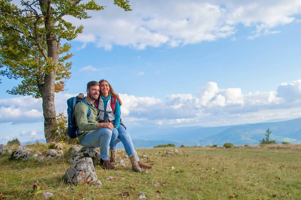 Par som sitter på en klippa och vilar under vandringen — Stockfoto