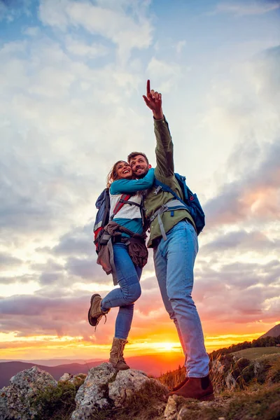 Paar op de top van een berg schudden opgeheven handen — Stockfoto