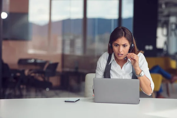 Ritratto di donna concentrata in cuffia che partecipa al webinar in ufficio — Foto Stock