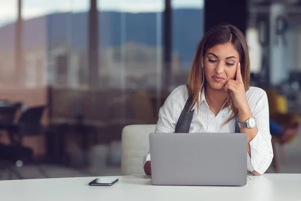 Ritratto di donna concentrata in cuffia che partecipa al webinar in ufficio — Foto Stock