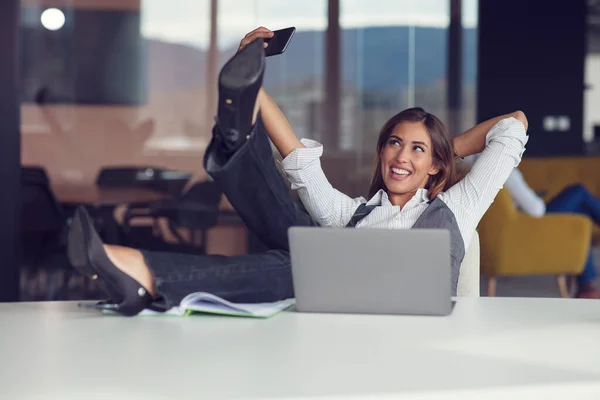 E 'ora di rilassarsi. Allegro giovane bella donna tenere le mani dietro la testa mentre seduto al suo posto di lavoro — Foto Stock