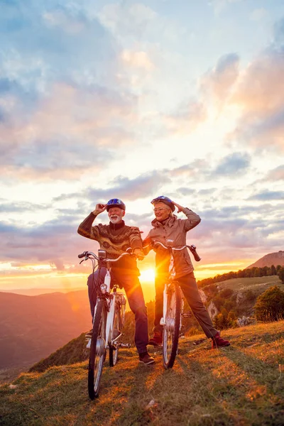 Personas mayores activas que tienen paseo con bicicleta en la naturaleza otoño. Que tienen tiempo romántico al aire libre. —  Fotos de Stock