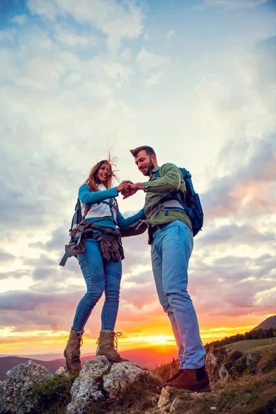 Paar op de top van een berg schudden opgeheven handen — Stockfoto