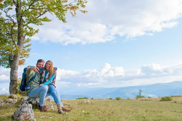 Pár ül a sziklán pihentető túrázás közben, és a szelfi — Stock Fotó