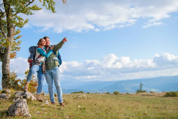 Two hikers with backpack standing on top of a mountain and look — Stock Photo, Image
