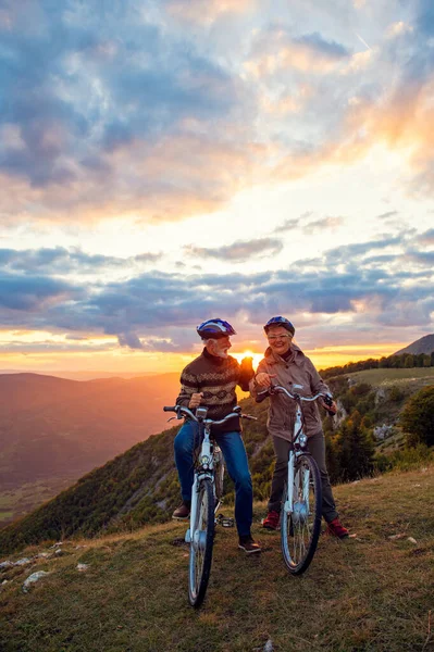 Pareja mayor en paseo en bicicleta en el campo —  Fotos de Stock