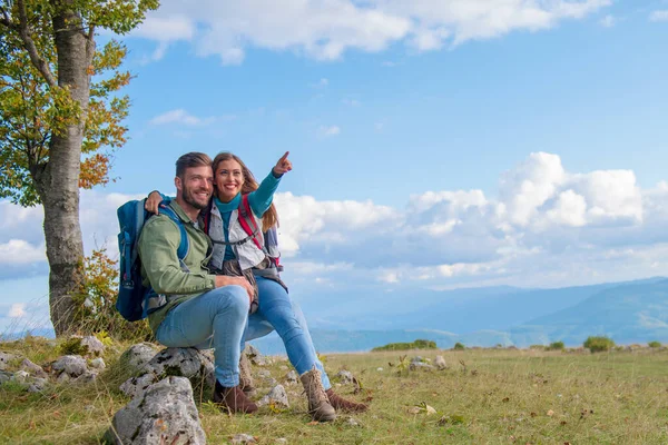 Två vandrare med ryggsäck står på toppen av ett berg och titta — Stockfoto