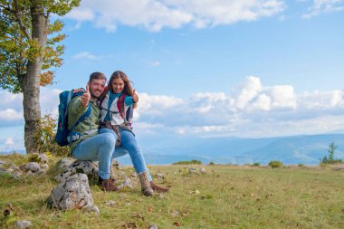 Kaya üzerinde oturan çift yürüyüş sırasında dinleniyor