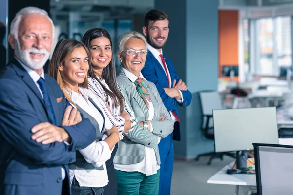 Businessteam in office, Happy Senior Businessman in His Office is standing in front of their team.