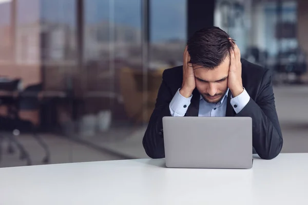 Je me sens épuisé. Jeune homme barbu frustré gardant les yeux fermés alors qu'il était assis sur son lieu de travail au bureau — Photo