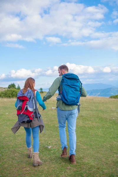 Happy couple hiking and enjoying a valley view. Photo taken from back. — Stock Photo, Image