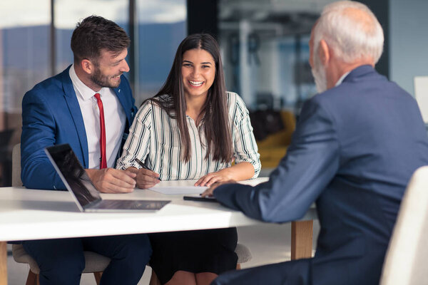 Young couple meeting financial advisor for home investment