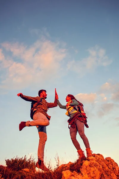 Pareja en la cima de una montaña sacudiendo manos levantadas —  Fotos de Stock