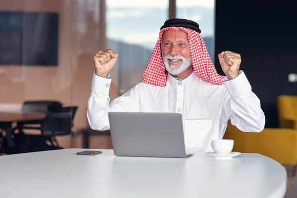 Arabischer Geschäftsmann feiert Sieg im Amt mit Laptop. — Stockfoto