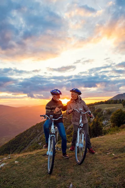 Pareja mayor en paseo en bicicleta en el campo —  Fotos de Stock