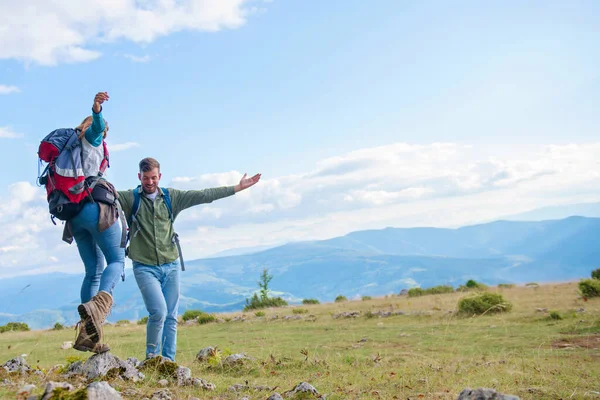 Dos excursionistas con mochila de pie en la cima de una montaña y mira —  Fotos de Stock
