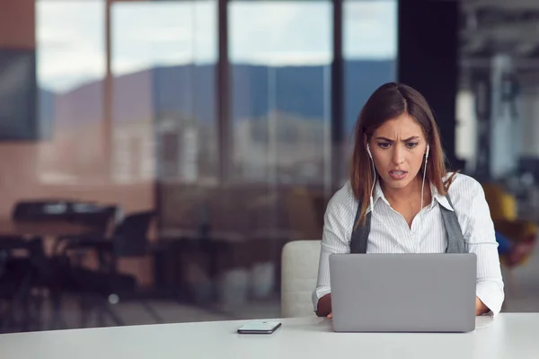 Ritratto di donna concentrata in cuffia che partecipa al webinar in ufficio — Foto Stock