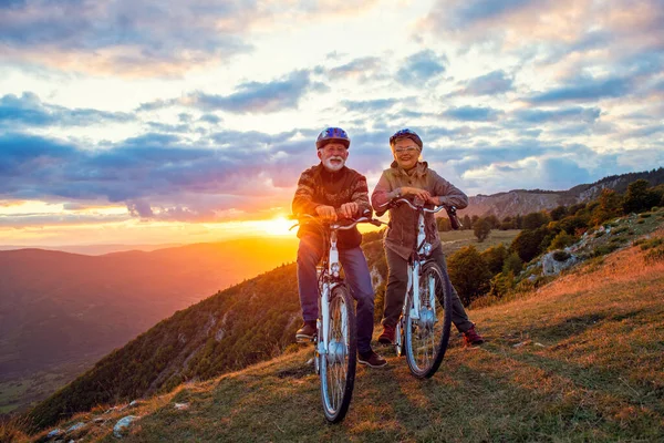 Active Senior Couple Riding Bikes In Park — Stock Photo, Image