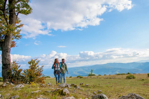 Happy couple hiking and enjoying a valley view — Stock Photo, Image