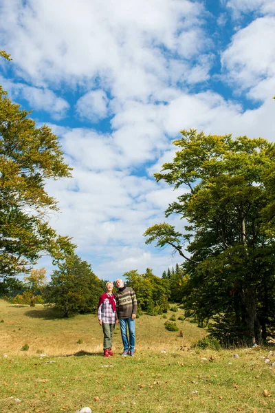 Starší pár na procházce v podzimní přírodě. — Stock fotografie
