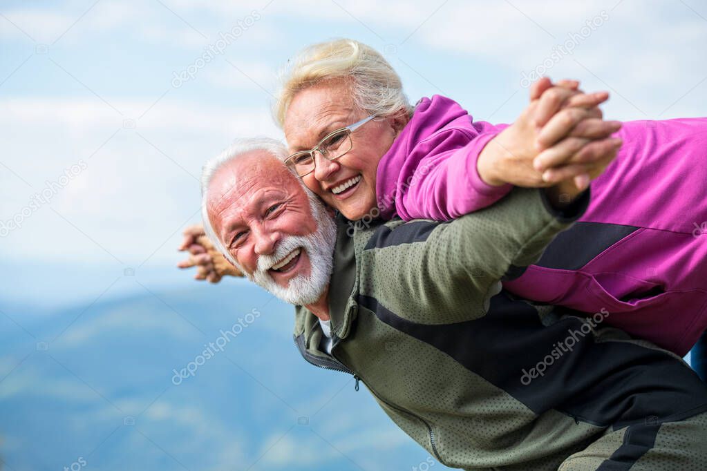 Happy senior couple smiling outdoors in nature. Grandparents, autumn.