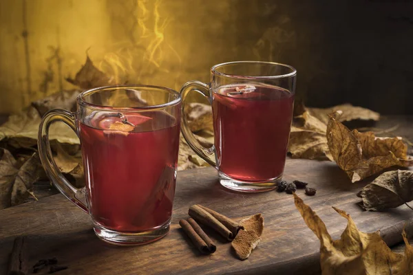 Two glasses of hot red mulled wine with spices, orange slices, cinnamon stick and anise star with. — Stock Photo, Image