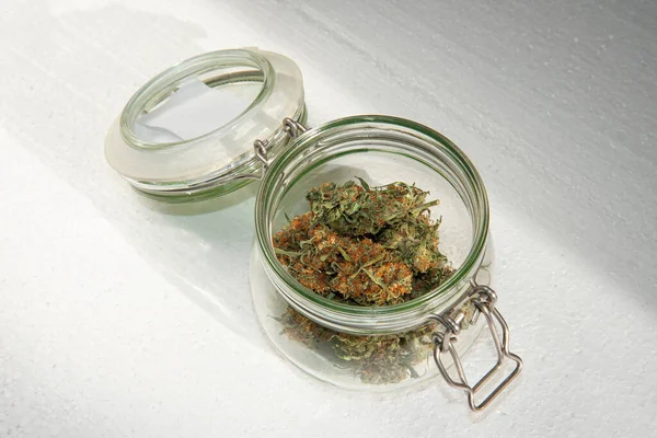 淡淡的背景下 放在敞开的玻璃瓶中晒干的大麻芽 — 图库照片