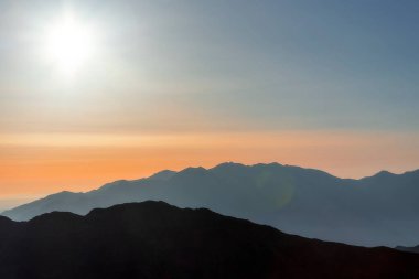 Gün doğumu arkaplan resminde dağ aralıklarının siluetleri