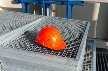 Metal ağdaki inşaatçı için turuncu koruyucu kask.