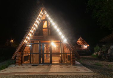 Teberda, Rusya 09,07,2021. Dağlardaki ahşap ev mavi gece gökyüzünün arka planına karşı..