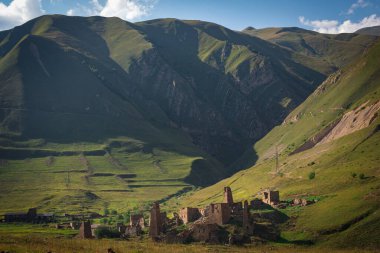 Kafkasya 'daki Kuzey Osetya' daki dağların arka planına karşı antik savunma kulelerinin kalıntıları.
