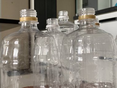 Transparent plastic bottles are on the floor