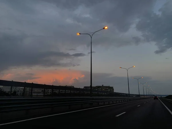 雨の中の夕日を背景にした道 — ストック写真