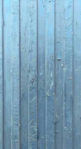 一个有粘贴广告痕迹的蓝色旧栅栏 — 图库照片