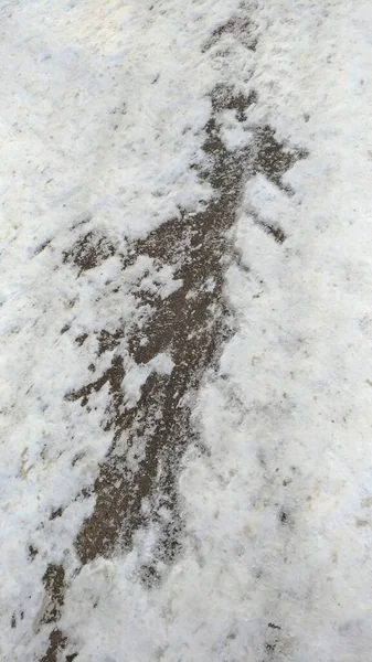 Asfaltweg, gedeeltelijk sneeuwvrij spoor — Stockfoto