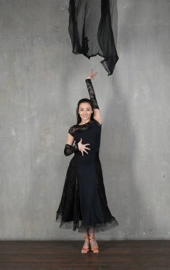 Duvarda bir kumaşla dans eden kadın.