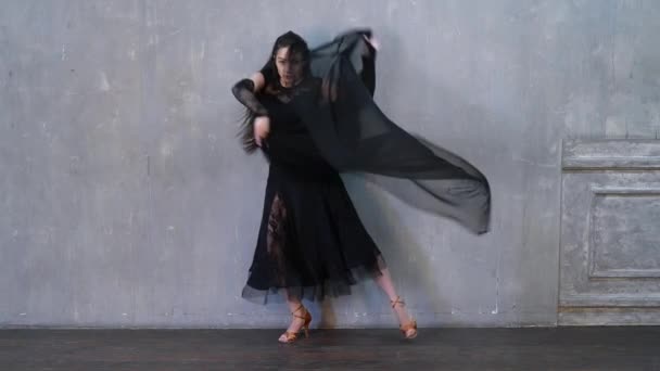 Vrouw dansend, slow motion, met een doek tegen de muur. Ballroom dans met hoge beenlift. — Stockvideo
