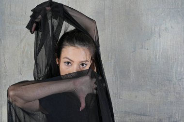 Duvarda bir kumaşla dans eden kadın.