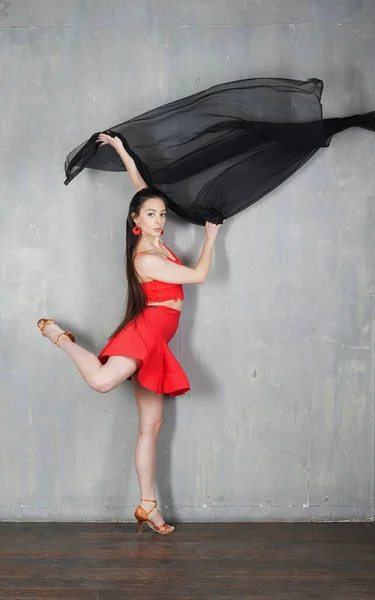 Woman dancer in motion with a cloth against the wall