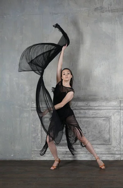 Woman dancer in motion with a cloth against the wall