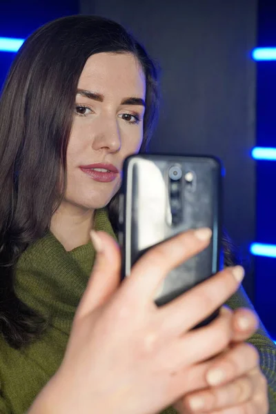 Κορίτσι βγάζει selfie στο τηλέφωνο με φόντο νέον φώτα — Φωτογραφία Αρχείου