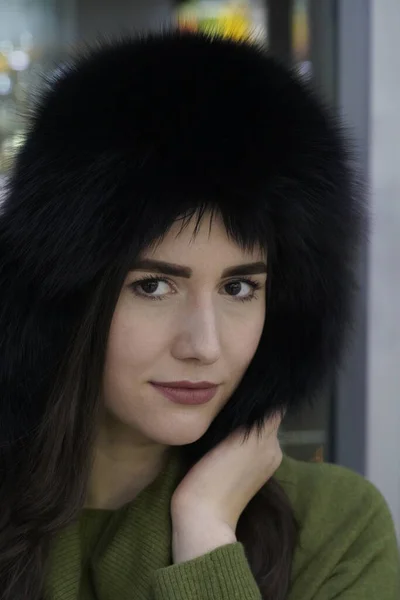 Portrait of casual style woman in winter fur hat close-up, face and hands on glittering background — Stock Photo, Image