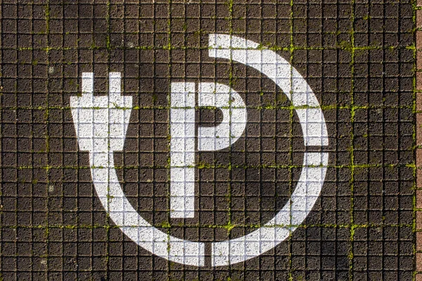 Electric vehicle symbol painted in parking lot.