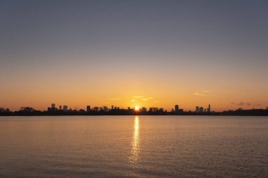 Kralingse Plas 'tan (Kralingen Gölü) görüleceği gibi Rotterdam ufuk çizgisinde gün batımı gölün durgun sularına yansıyan renkli gökyüzü