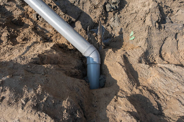 Plastic pipes in the ground during the construction of a building, bunner with copy space