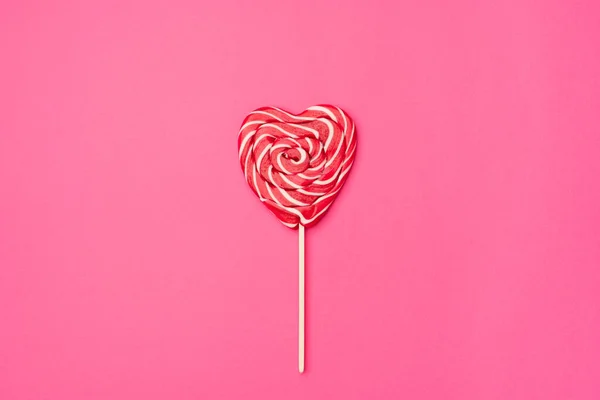 Bonbons sucette rouge en forme de coeur isolé sur un fond rose coloré vide. Symbole d'amour pour les femmes heureuses, Saint Valentin, carte postale romantique de voeux d'anniversaire — Photo